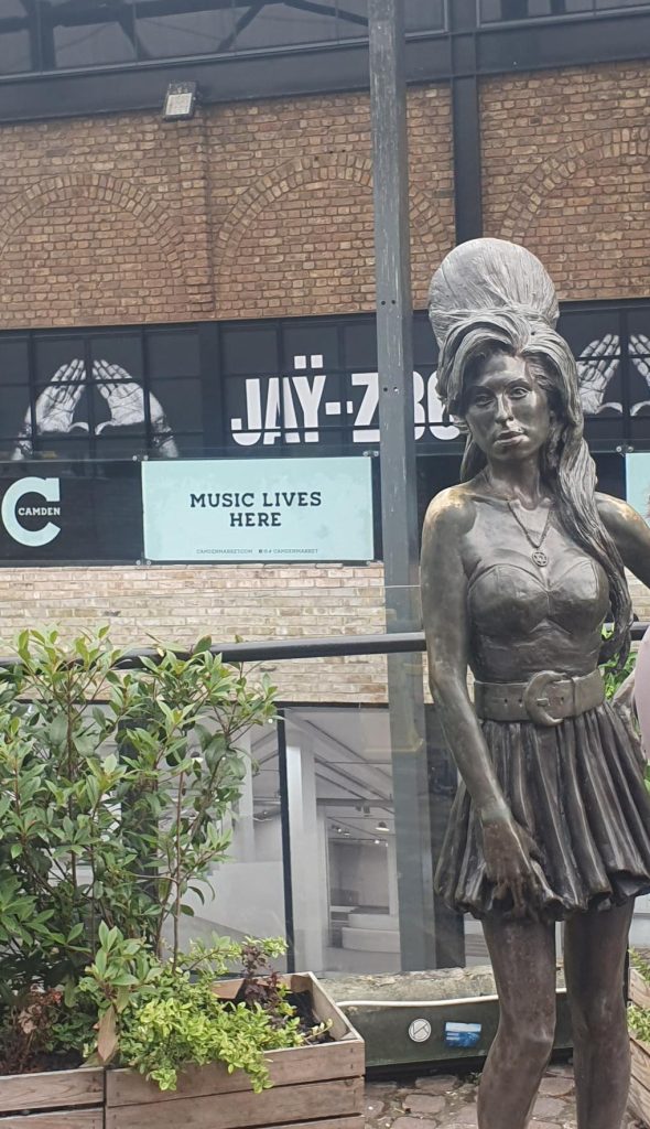 Bronze statue of Amy Winehouse with her signature beehive hairstyle at Stables Market in Camden, London, infont of UMusic Store.