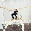 Artist Theo Triantafyllidis seated on his large spider-like Feral Metaverse sculpture inside his Athens studio.
